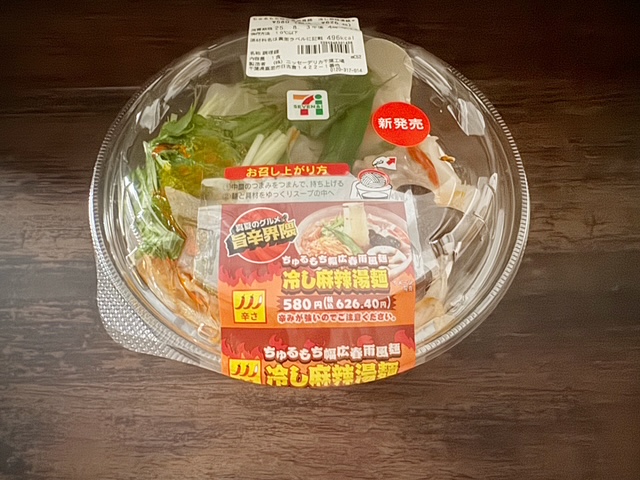 ちゅるもちハバヒロはるさめふうメン、ひやしマーラータンメンのパッケージ写真。透明なプラスチックの容器のしたに、まっかなスープがダイレクトにハイっています。そのうえのなかざらにメン、まっかなもやし、みずな、れんこん、おくら、きくらげがのっています。パッケージをはがし、フタをあけてなかざらのつまみをつまんでうえに引っ張りながら、めんと具材をスープにいれて食べます
