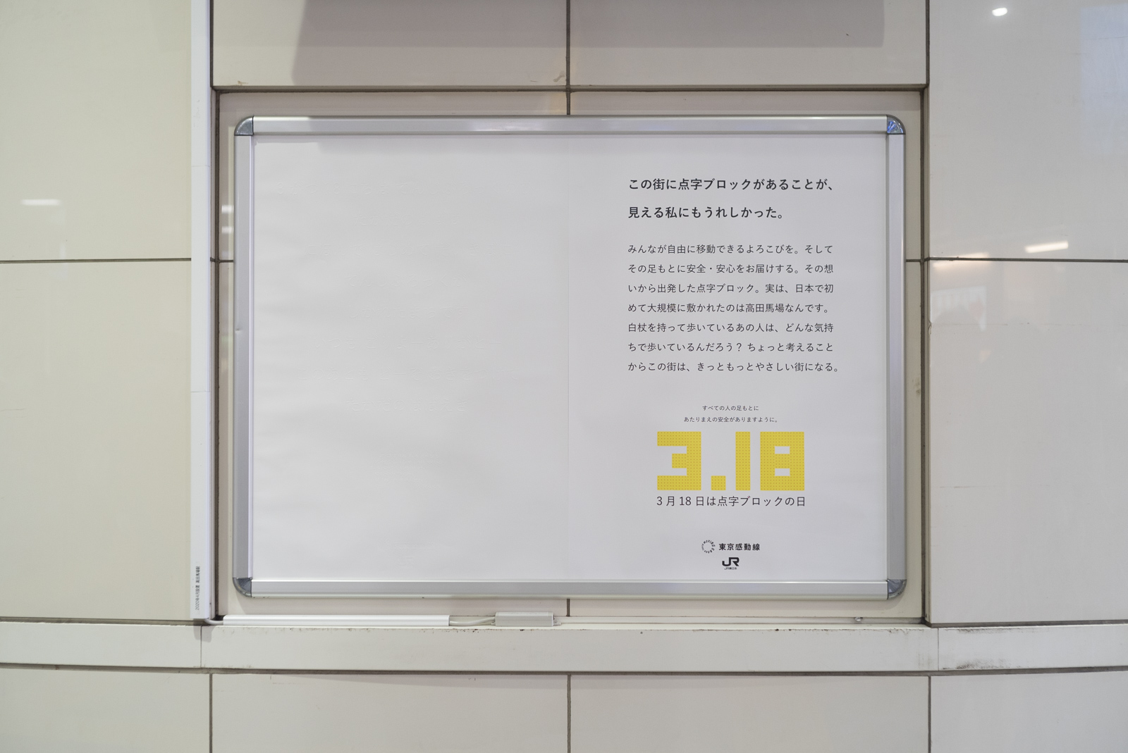 ジェイアールたかだのばば駅に掲示された真っ白なポスターの写真。ポスターの左側には浮き出し文字でメッセージがかかれています