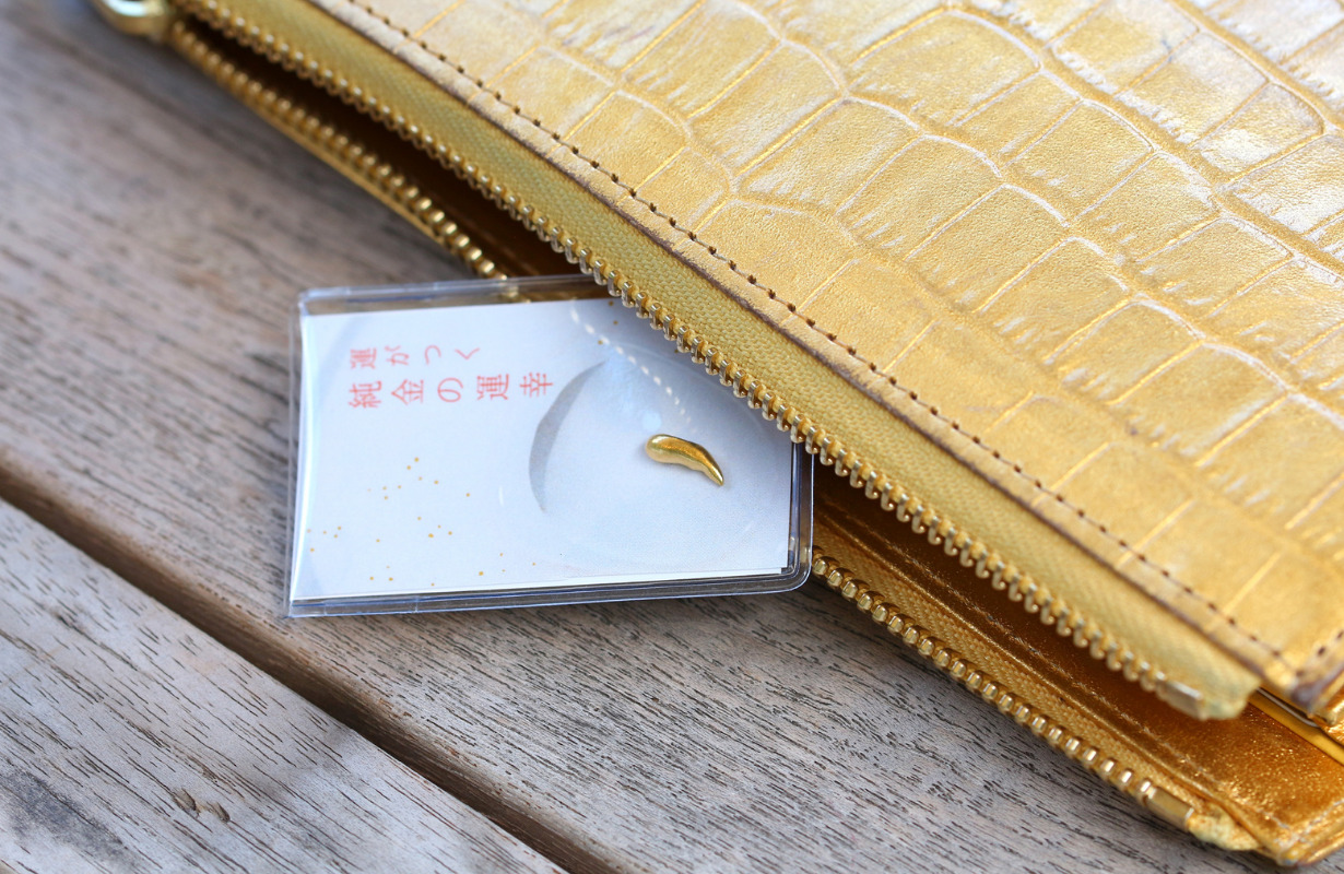 財布から「運がつく純金のうんこう」と書かれているパッケージに入ったバナナ形がたのうんこうが出ている写真