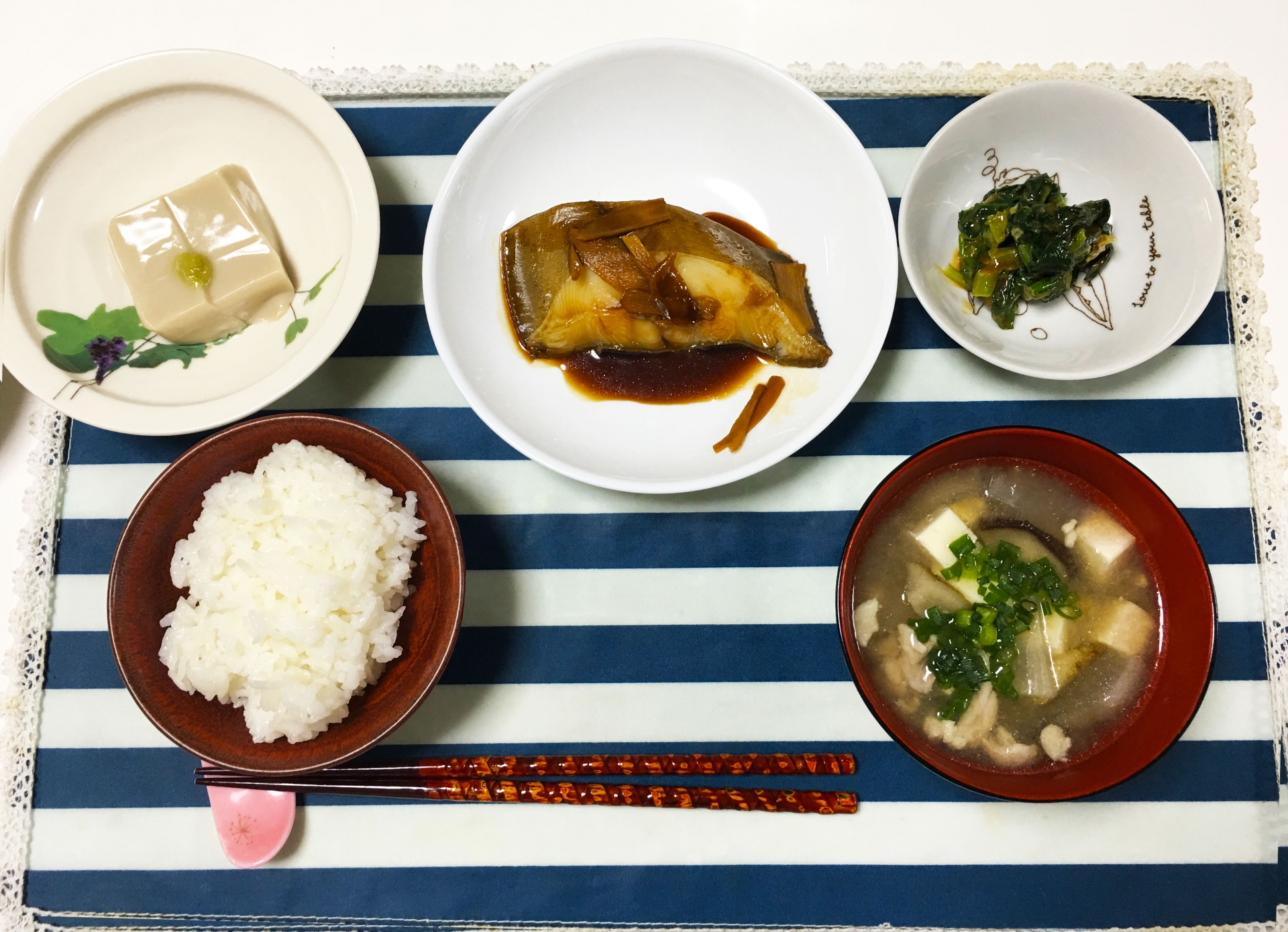 テーブルにのった食事の写真。食卓にはカレイの煮付けやごま豆腐、みそ汁、白米などバランスの良い食事が並んでいる
