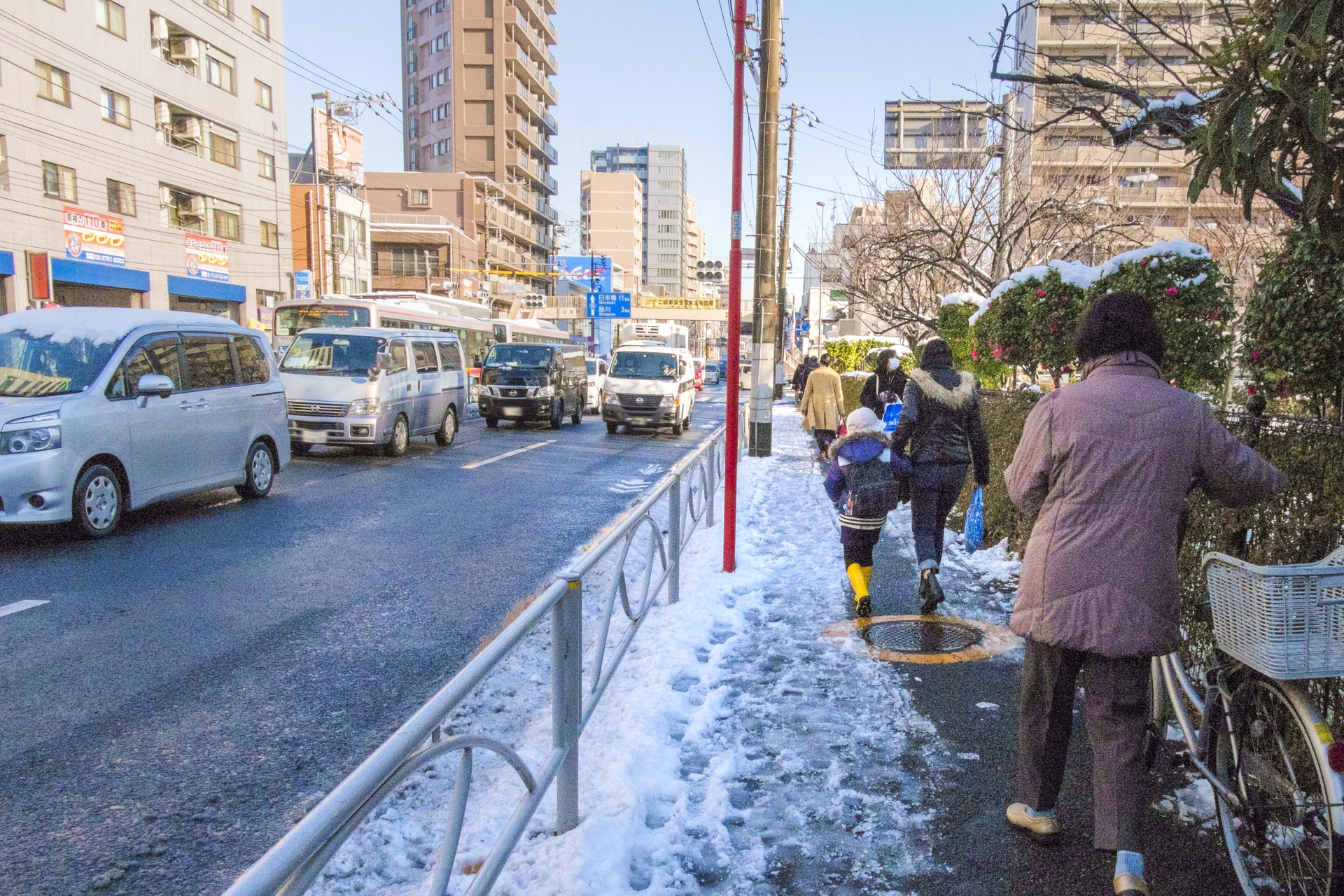 降雪ごのあさ、歩道を歩く女性ら
