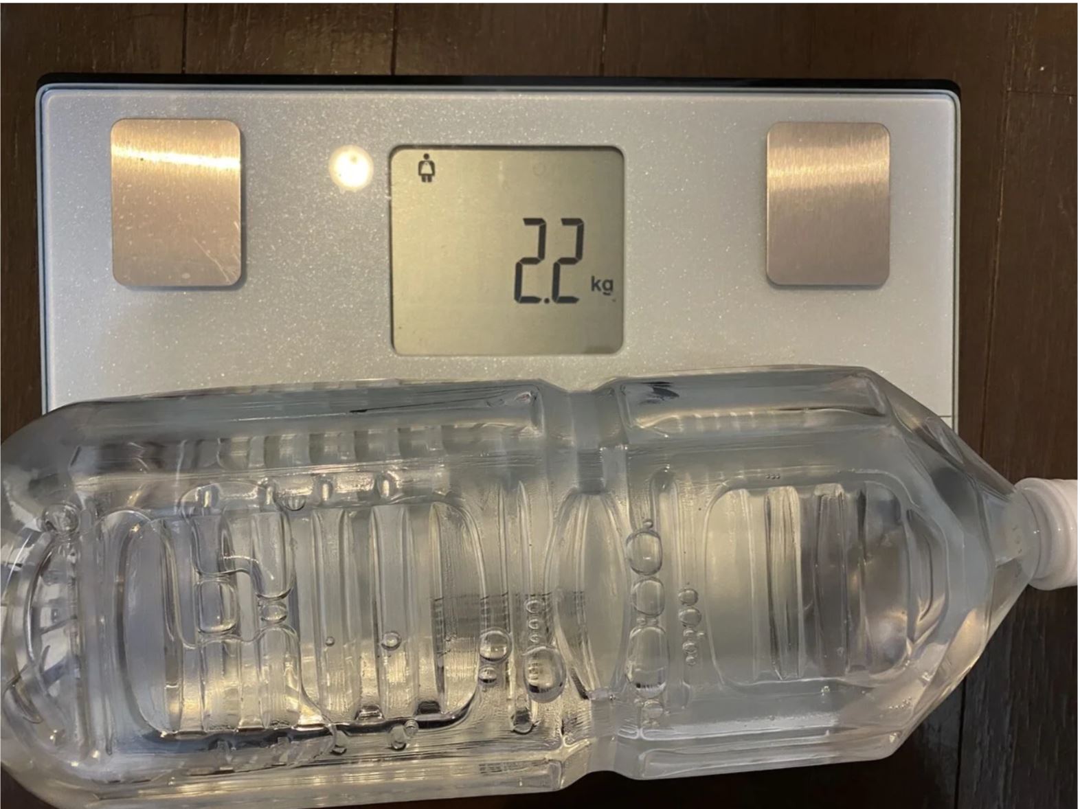 タニタのたいそせいけいにのせてペットボトルの重さを測っている写真。２．２キログラムと表示されています