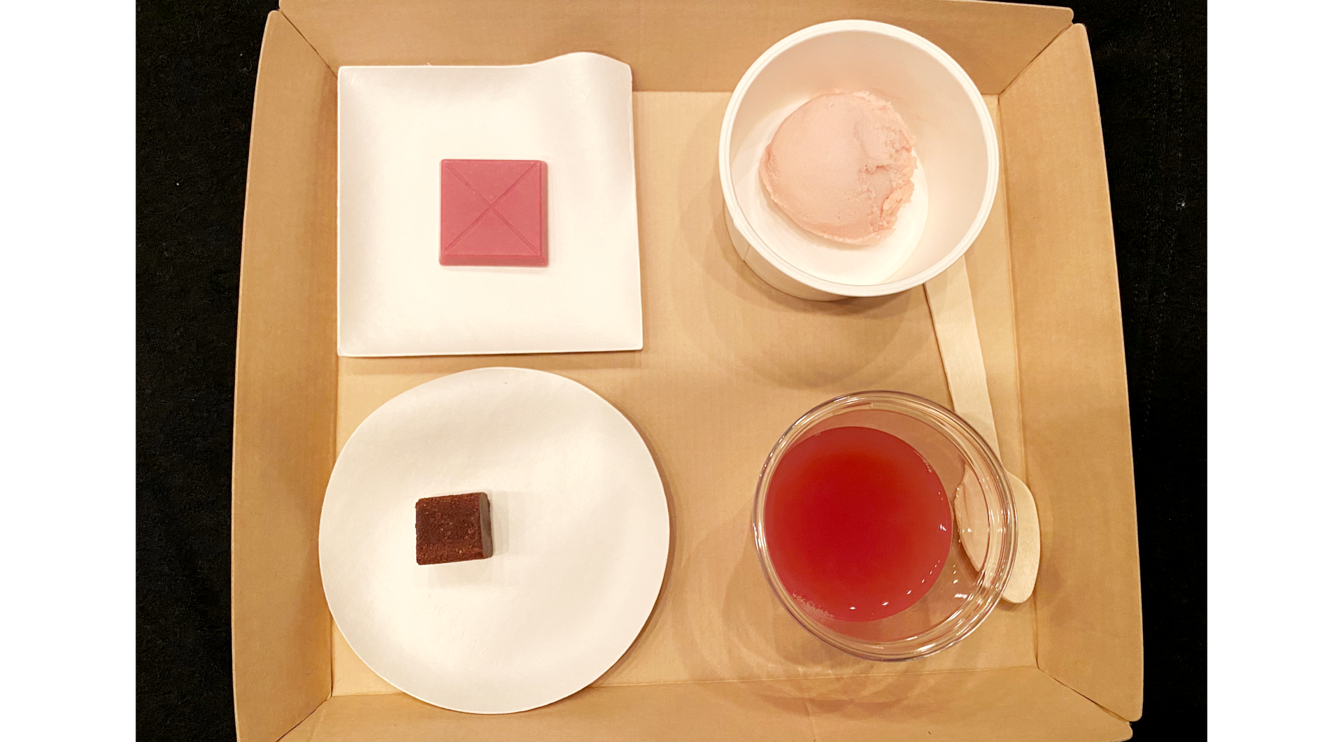 発表会会場での試食として提供された４商品の写真。四角い紙製のトレーに載ったかみざらに商品が入っています。ドリンクは赤い色がきれいにみえる透明のカップに入っています。