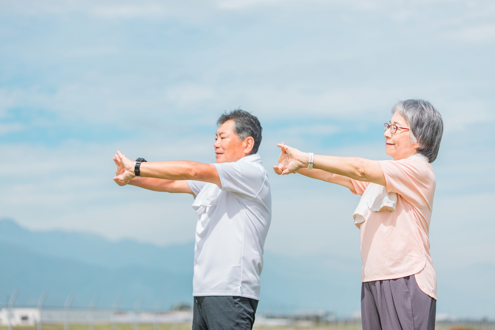 公園で体操をする高齢の夫婦の写真