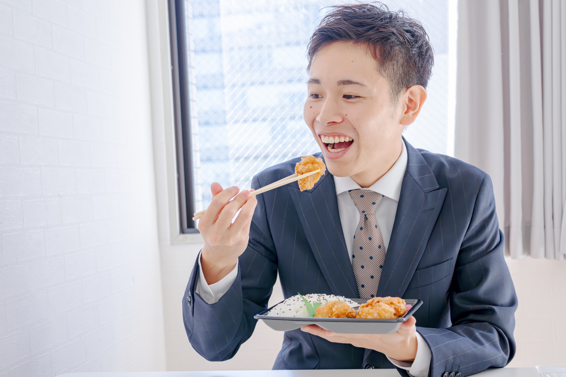 オフィスでランチを食べる男性