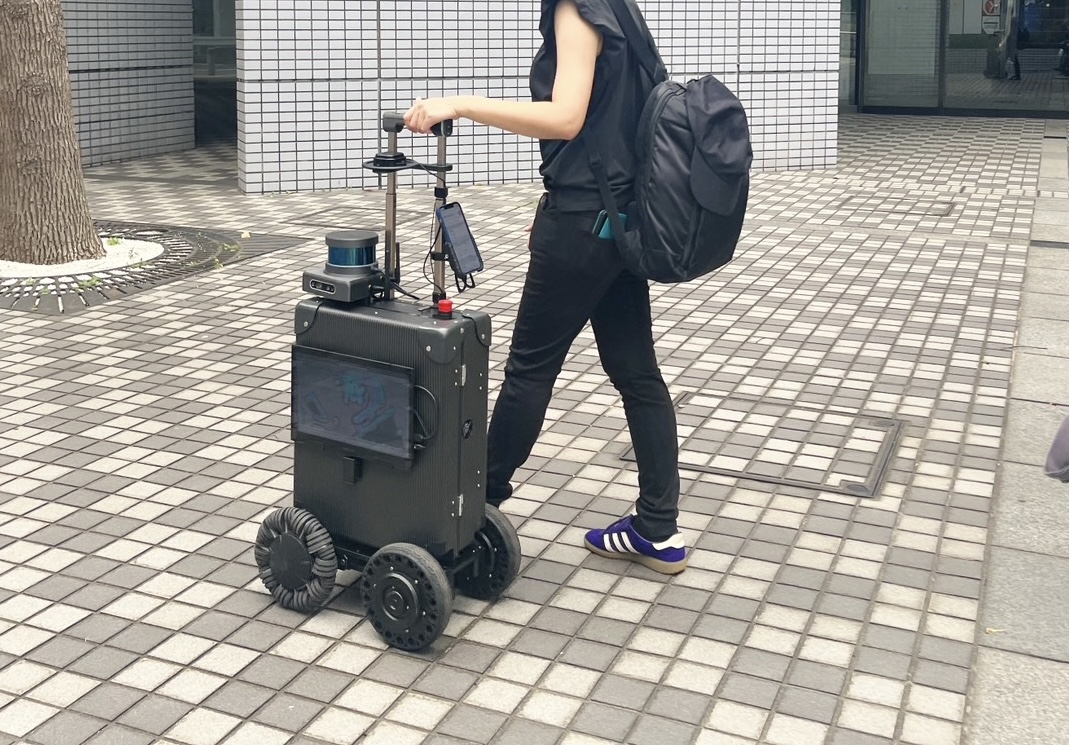 今回の屋外用エーアイスーツケースに誘導されて歩く女性の写真