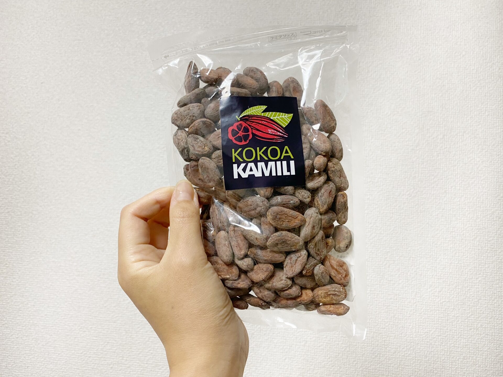 アマゾンで購入した、プラスチックの袋にハイったカカオ豆を持っている写真