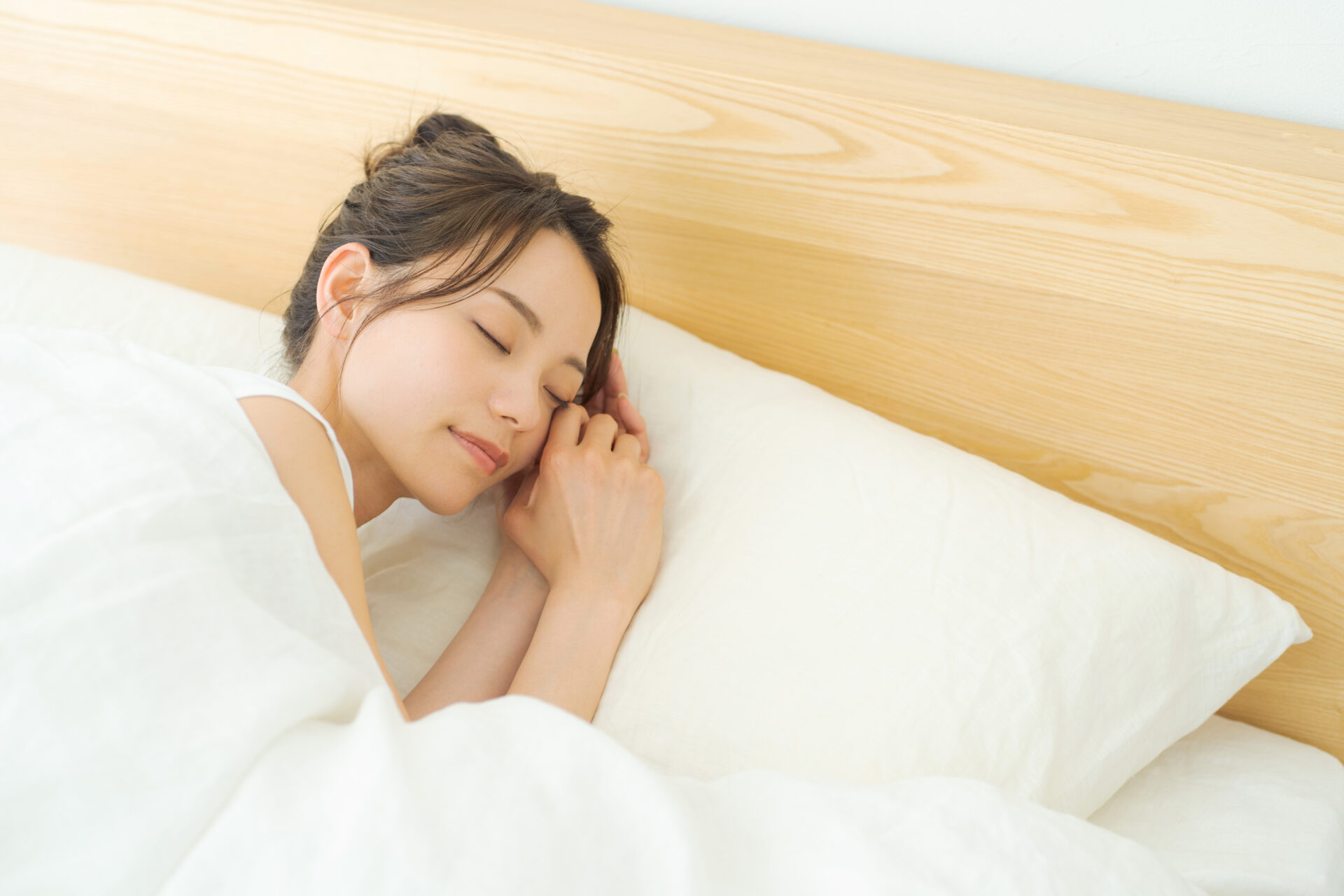 ベッドで気持ち良さそうに眠っている女性の写真