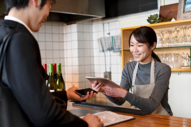 お店での会計じに、自分のスマホのQRコードを提示して、店員さんに読み取ってもらっている様子の写真。さいわい自分のスマホの画面は壊れておらず、自分のカメラで読み取るわけではないのでこの方法であれば決裁できました