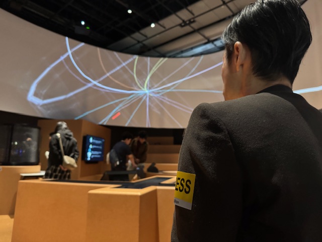 未読の宇宙の映像展示を楽しんでいるしらとりさんの後ろ姿の写真。没入感があります