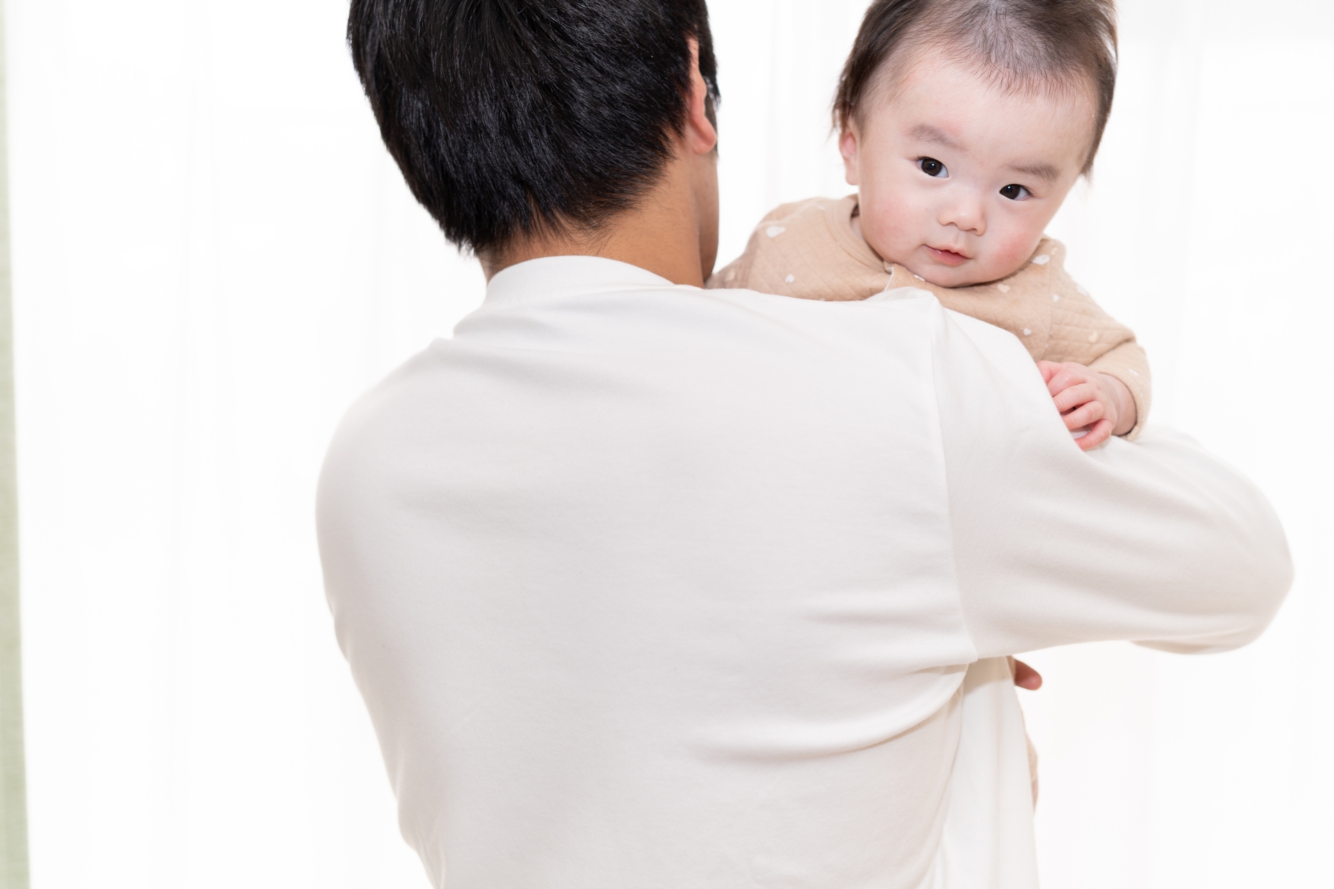 子どもをだっこするおとうさんの写真です
