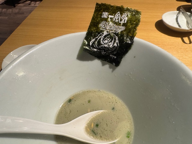 スープまでほとんど飲まれたラーメンのうつわと、うつわのフチに避難させたままの海苔の写真