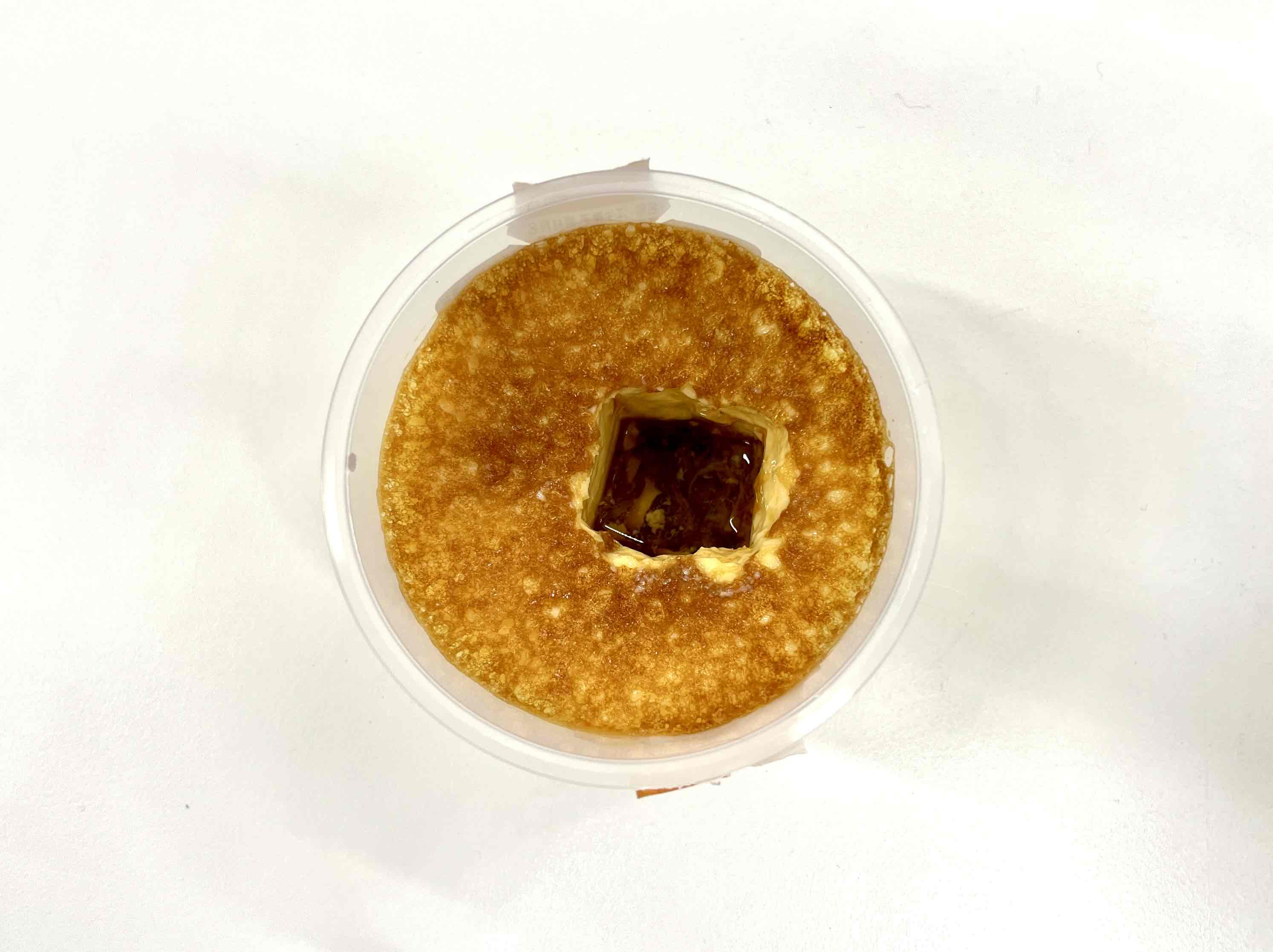 とうふこばちスプーンでプリンを掘って穴をあけた写真。奥のカラメルがみえています