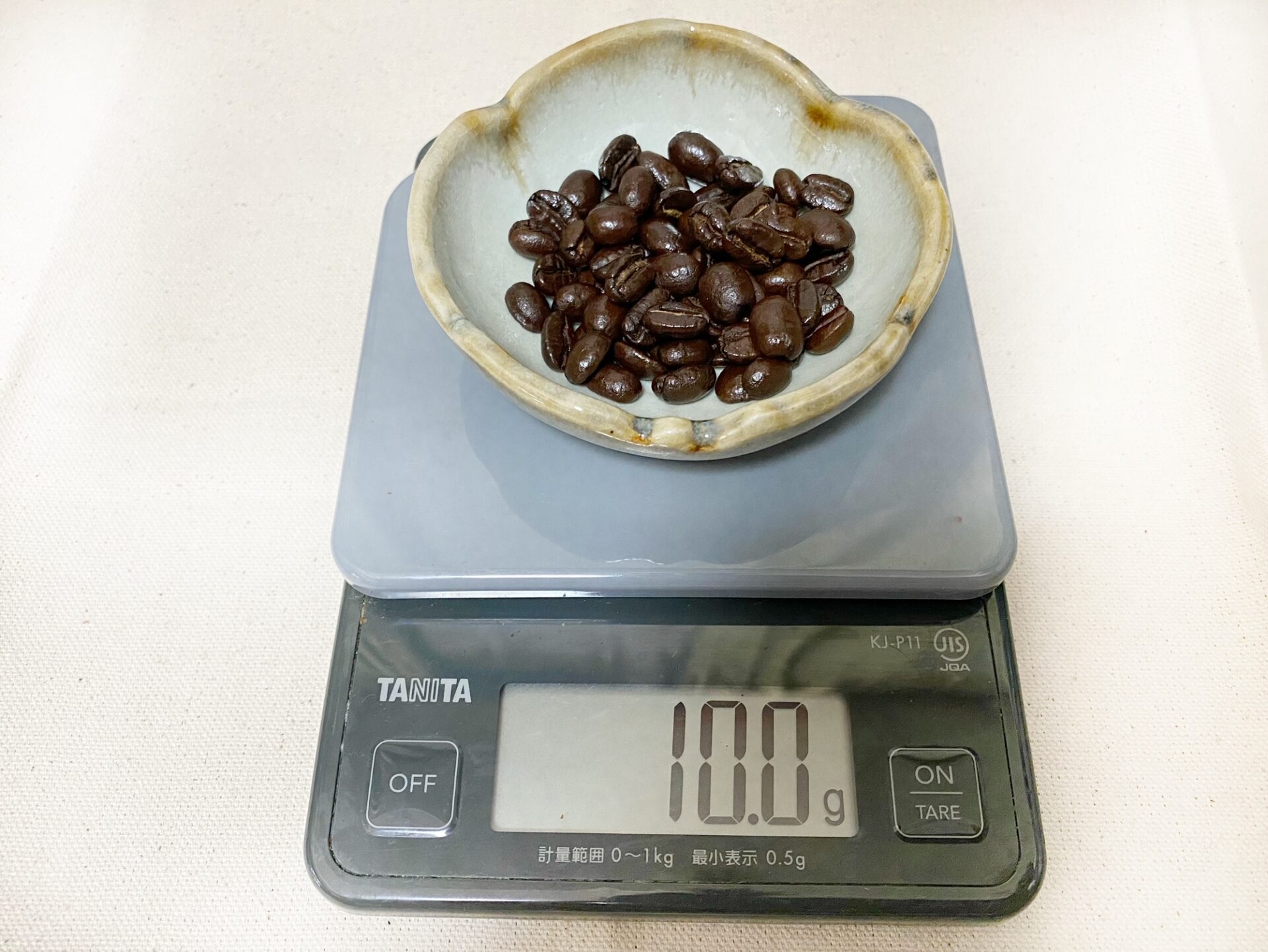 クッキングスケールのお皿はそのまま、コーヒー豆を１０グラムのせた写真。１０.０グラムと表示されています