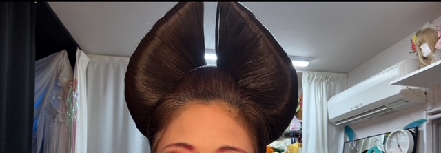 変身途中のあたまからまゆげまでを写した写真。イチョウみたいなかたちのかつらがあたまについています