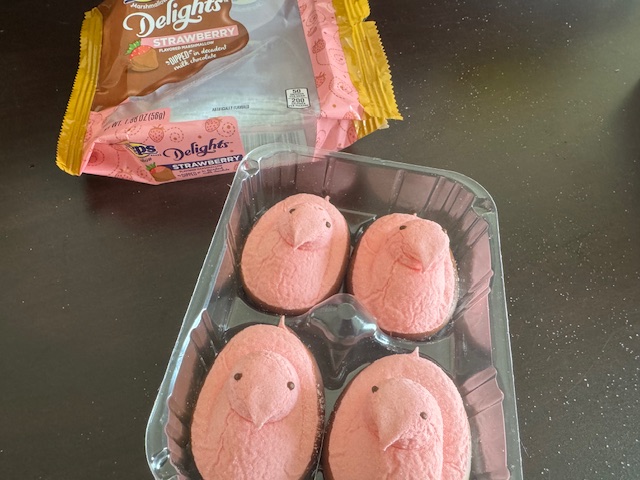 ひよこの下のほうにチョコがついているパターンのピンクのピープスのパッケージと、ふくろからだしたピンクのピープスが並んだ写真。こちらわよっついり、あじわストロベリーです