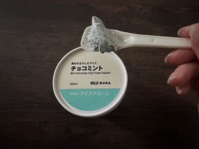 カップのふたと、スプーンですくったチョコミントの写真。うすいブルーで、ところどころにみえるこまかい黒いつぶつぶがチョコです