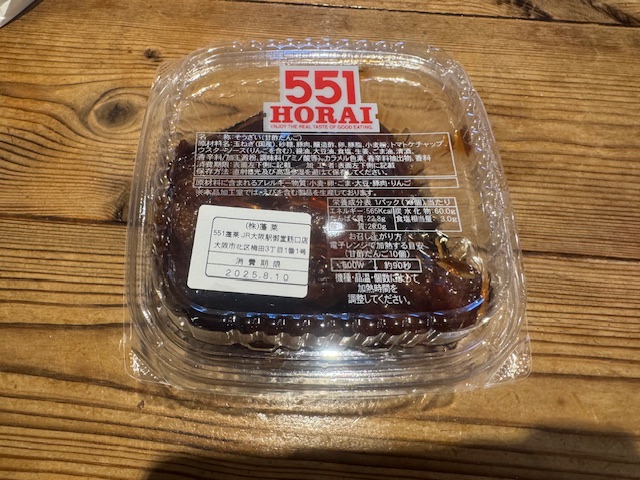 透明なしかくいプラスチックのケースに入れられたあまずだんごの写真。フタのしほうどこからでも開封しやすいようになっており、フタを開けるとダイレクトに肉だんごがハイっています。全体的に赤茶色っぽい色合いです