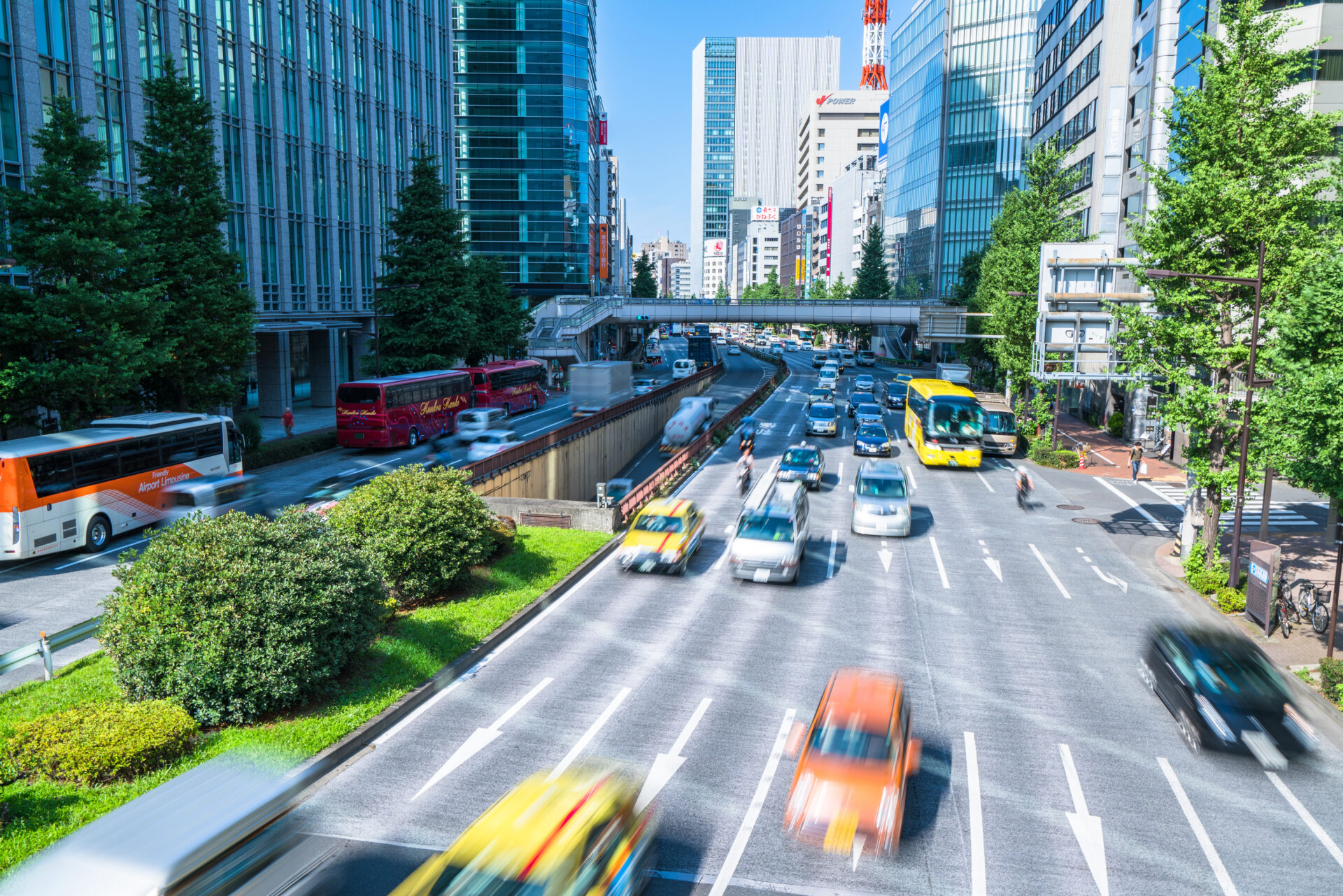都会のビル群とその間の道路を忙しく走るたくさんの車の写真
