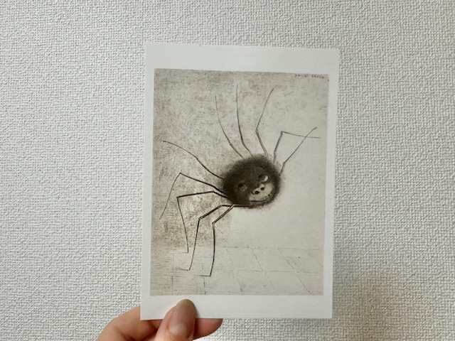 展示されていた「くも」のポストカードを手で持った写真。ミュージアムショップで購入しました。リトグラフで描かれた作品です