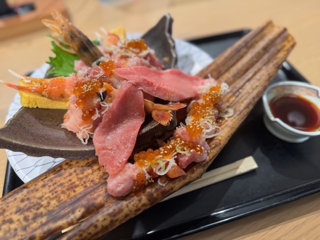 おおきなお盆にのった、豪快ブツぎり15種たいりょうどんの写真。お皿も豪華でおもいけど、乗っているネタもごうかです