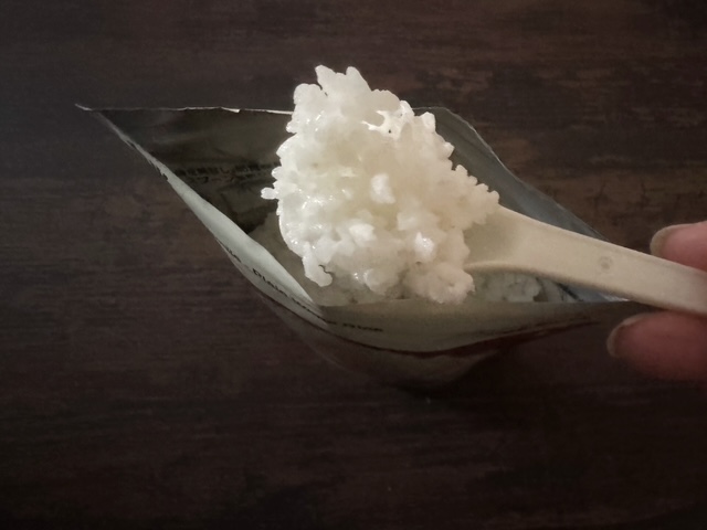 フクロのなかから付属のスプーンでごはんをすくった写真。このままお茶碗によそって出したら気づかないだろうと思えるくらい、よく見るいつものごはんです