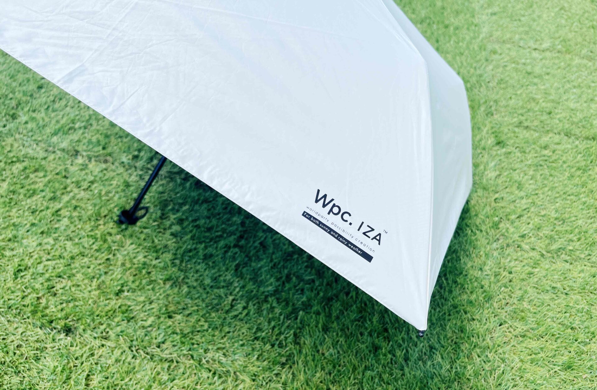 日傘についた「wpcイーザ」のロゴマークのアップ写真