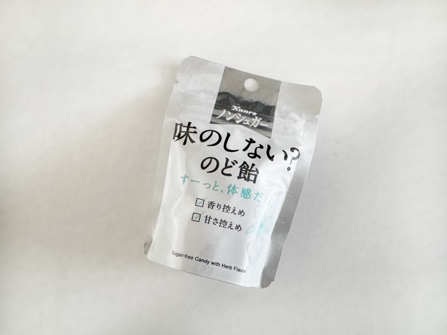 味のしないのど飴のパッケージ写真。大人の女性の手のひらに収まるくらいのサイズのジッパーつきのふくろに、ダイレクトにのど飴がすうつぶハイっています。ひとふくろ25グラムいり。ふくろは白を基調としたデザインで、黒い文字で味のしない?のどあめとかかれています。このほか、飴のデザインやハーブのイラストなども描かれています
