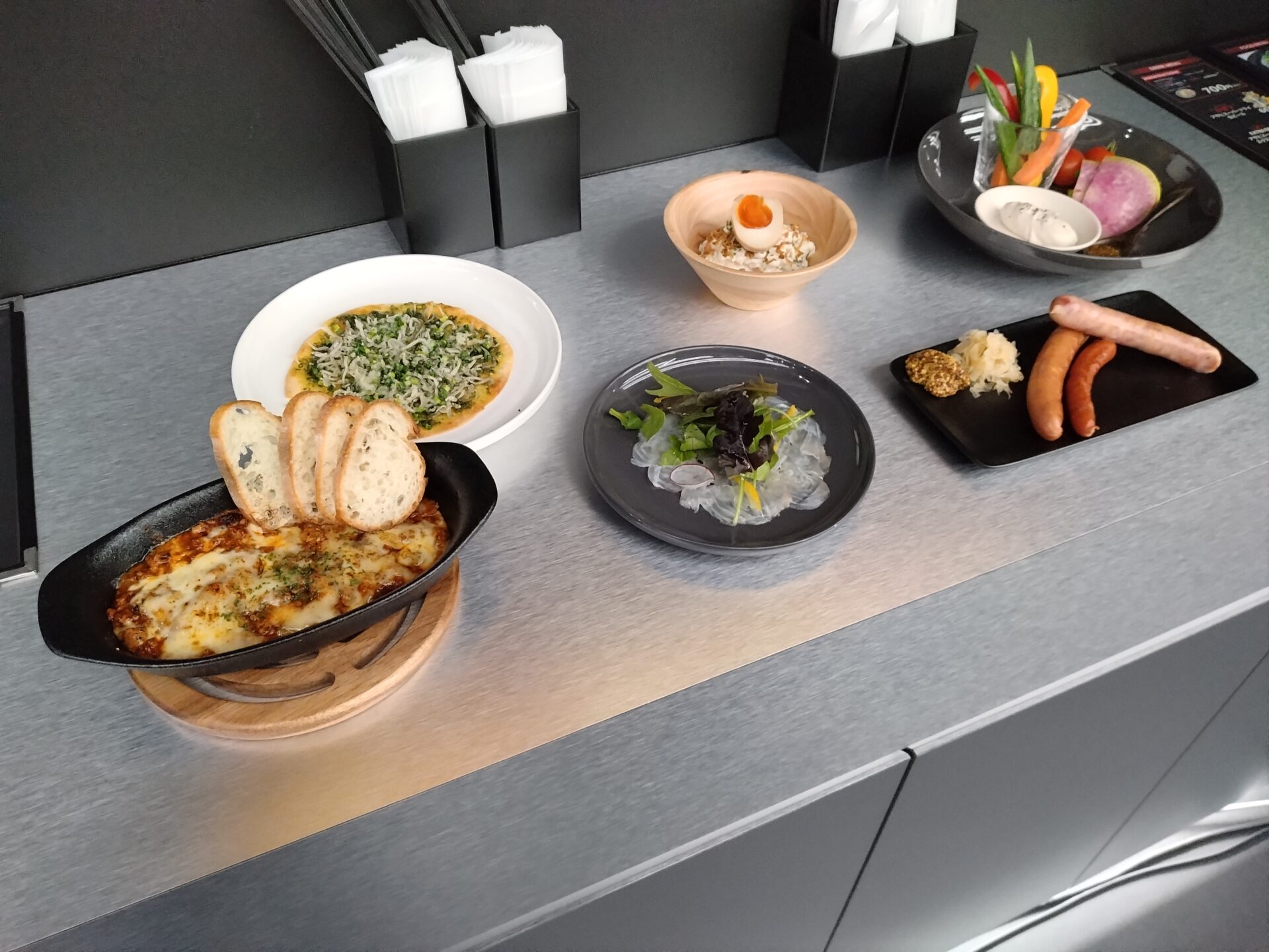 フードメニューの写真です。ソーセージや野菜など、ビールに合いそうなメニューが6種類ならんでいます