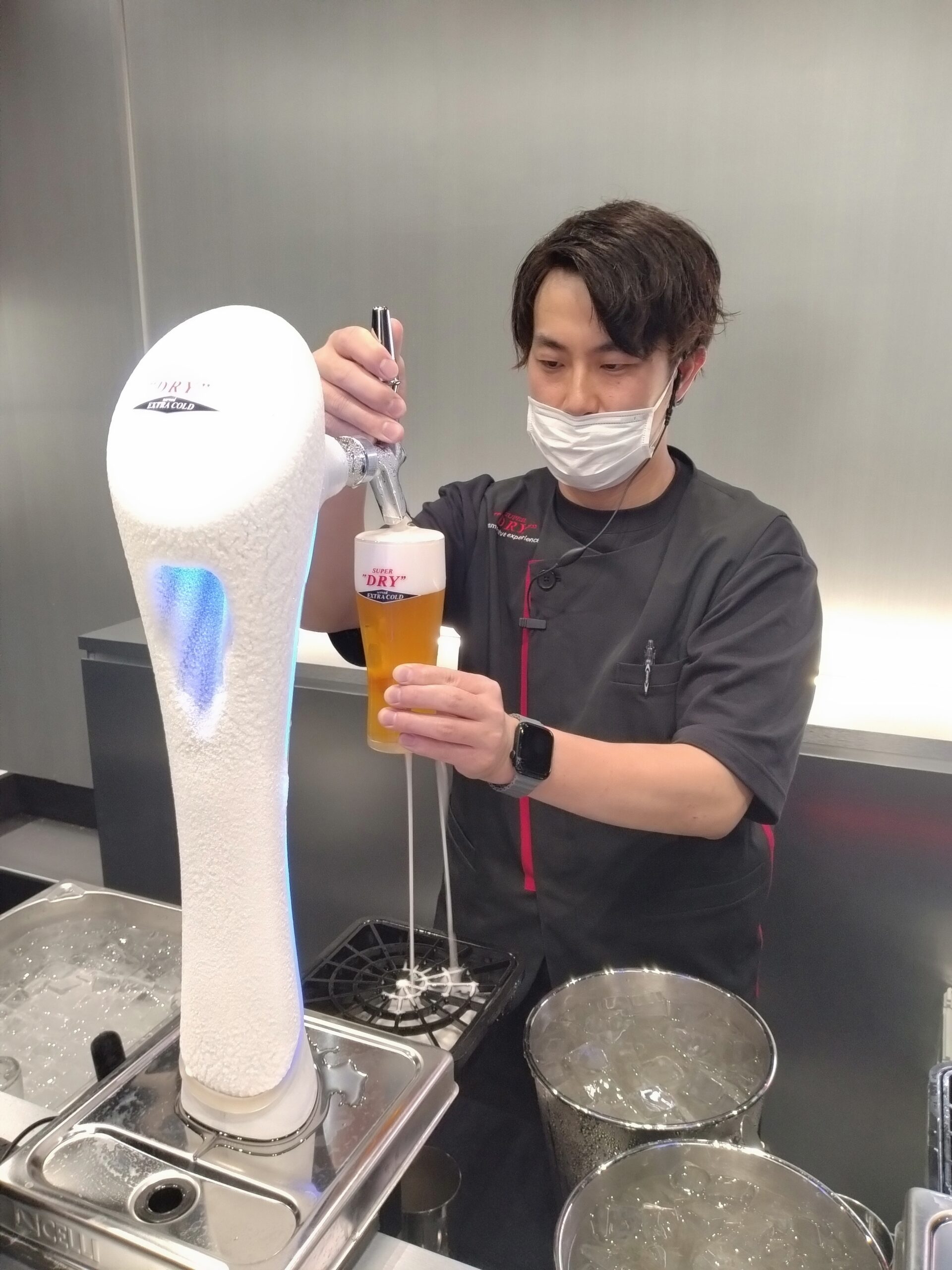 ビールを注ぐ男性スタッフの写真です