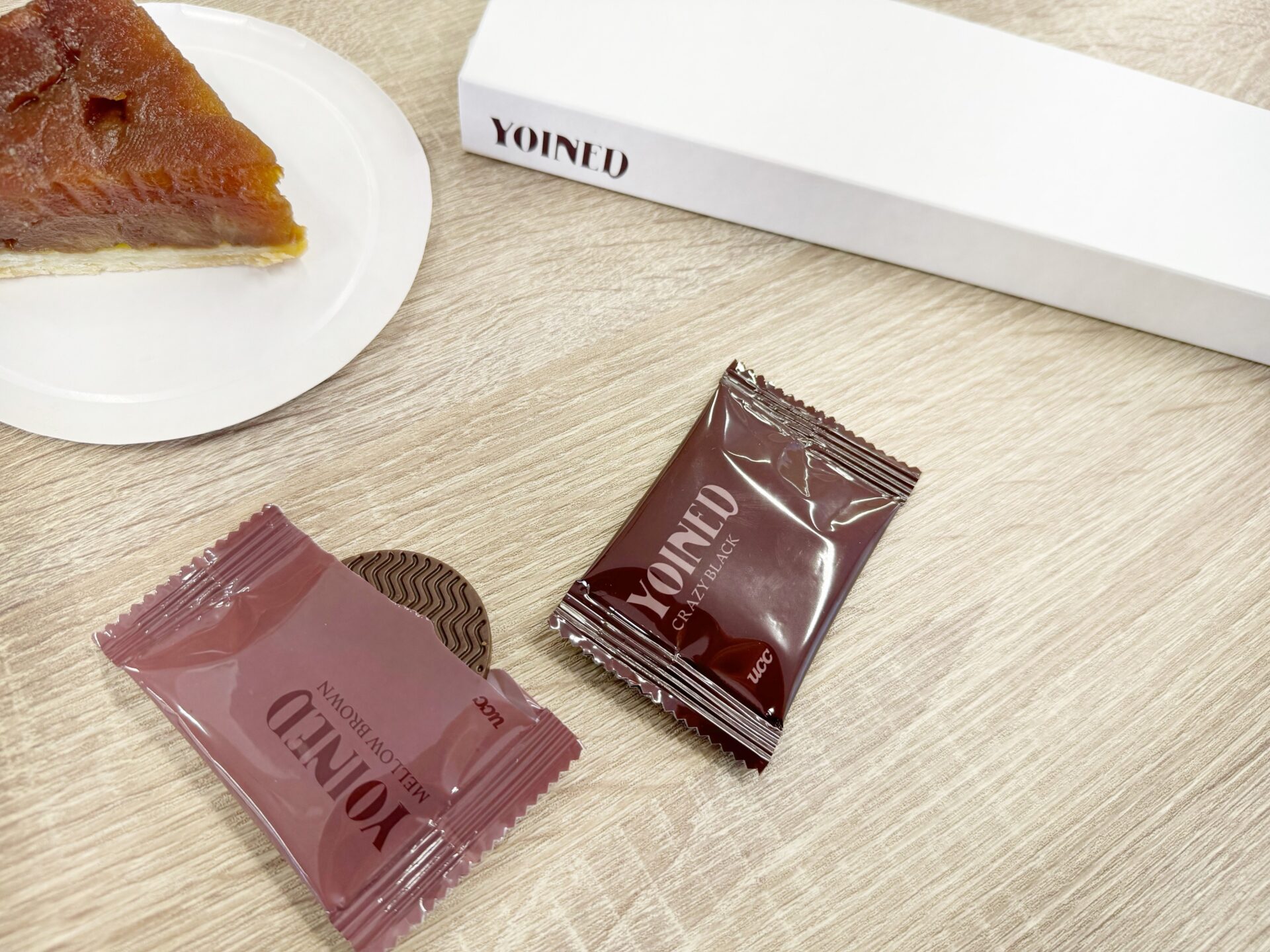 ケーキと、ヨインドの2種類のフレーバーの個包装のパッケージと、まっしろなそとハコの写真