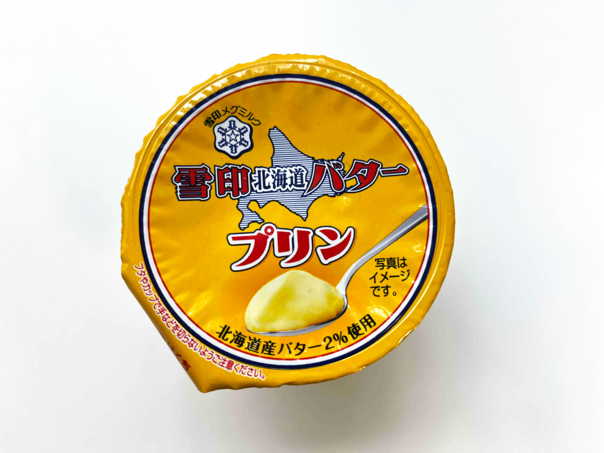 ゆきじるし北海道バタープリンのフタの写真。北海道さんバター２％使用とかいてあります