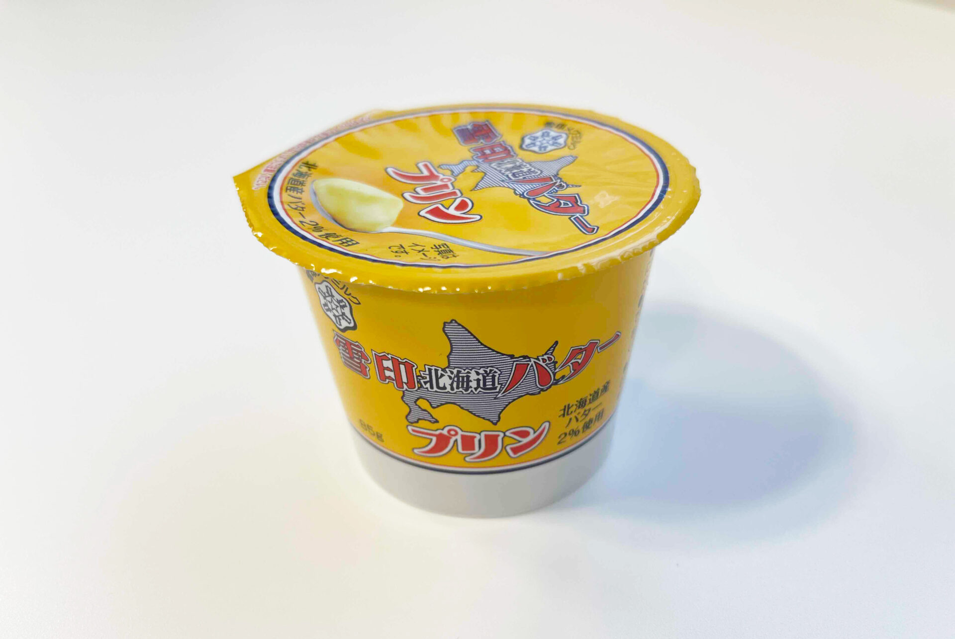 ゆきじるし北海道バタープリンの商品写真。ゆきじるし北海道バターのような、全体的に黄色いパッケージです