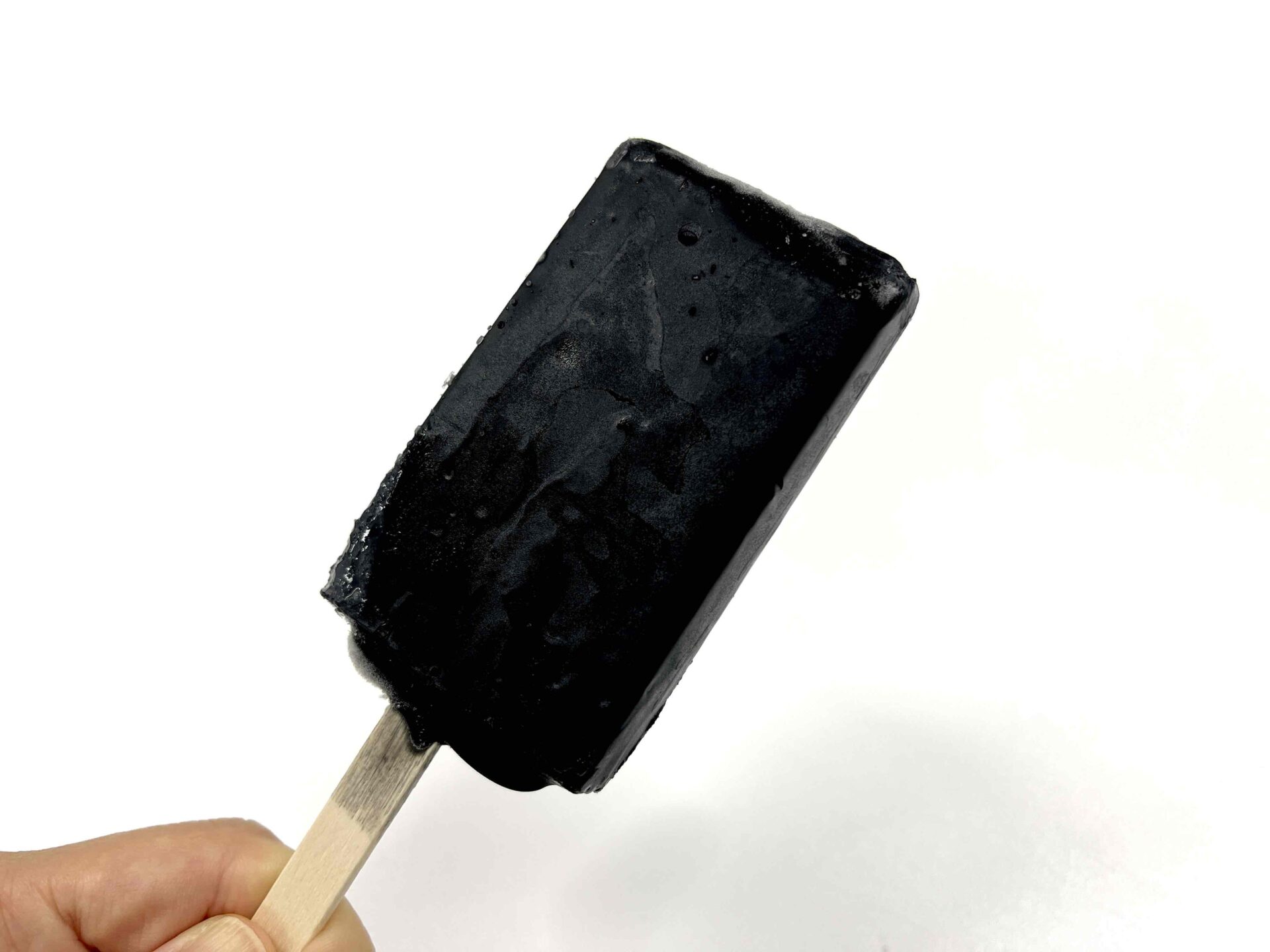 漆黒のチーズケーキアイスクリームの写真。スティックタイプのアイスクリームで色は真っ黒です