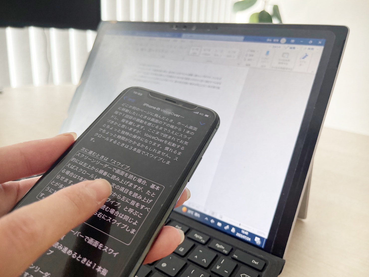 パソコンとアイフォンを使ってスクリーンリーダーで原稿チェックをしている様子をうつした写真