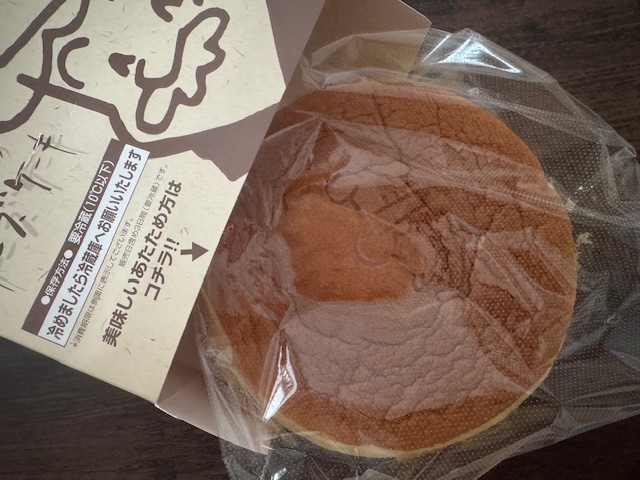 紙のハコからだしたやきたてホールサイズのチーズケーキの写真。ホールのチーズケーキわ、紙製のハコにかぜとおしのよさそうな透明のふくろにハイっています。自分ですきな大きさにカットして食べるスタイルです