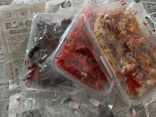 くるまれていたしんぶんしのうえにのった、くろ、あか、きいろっぽい3種類のカラーのゲソてんが1種類ずつ袋にハイッタ写真