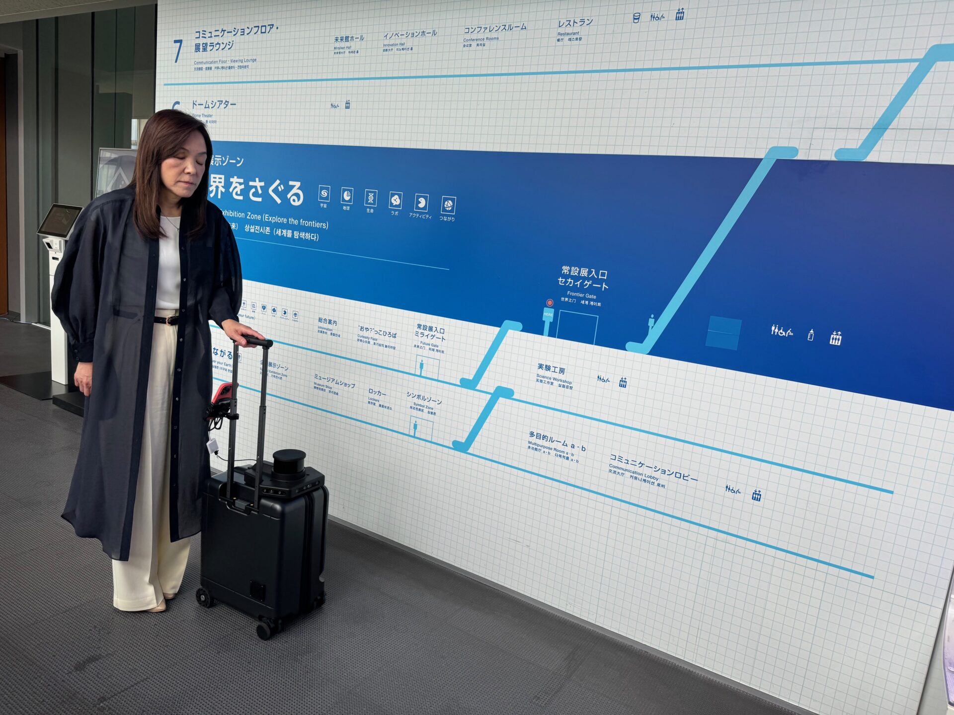 ふたたび歩き出したエーアイスーツケースと、浅川館長の写真