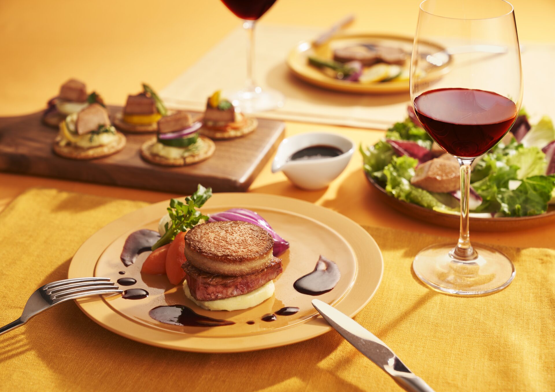 赤ワインとグラフォアを使った料理がテーブルに並べられているようす