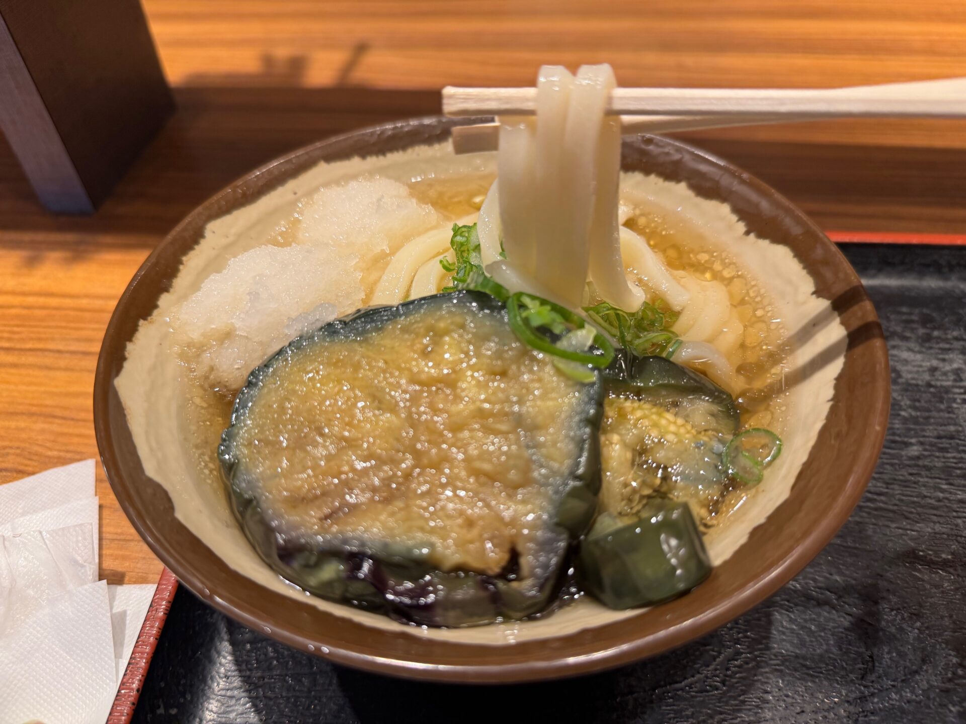 うどんを箸あげしている写真。白くてつやつやしたうどんが美しいです