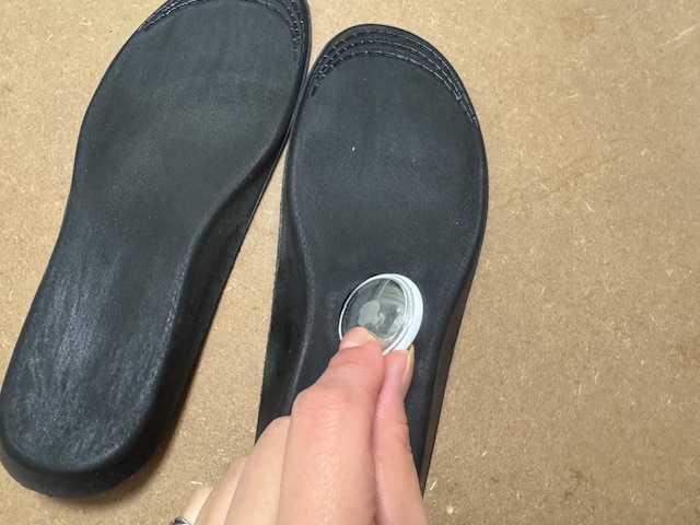 ひだりあしのインソールにエアタグをいれようとしている手元の写真