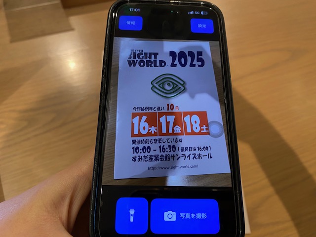 スイフトアイを開いてサイトワールドのパンフレットを写した写真。ひだりうえに情報、みぎうえに設定、ひだりしたにライト、みぎしたに撮影ボタンがついています