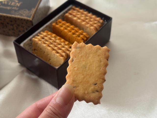 サワークッキーをいちまいてでもった写真。長方形のうすいクッキーです。背景にわパッケージが映り込んでいます