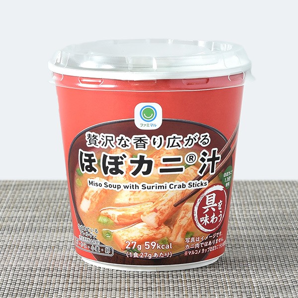 ほぼカニじるの商品パッケージの写真。ほぼカニじるわカップラーメンのような円柱のかたちのカップにハイっており、ふたをあけて、なかにハイッタフクロの粉末や具をカップにいれてお湯をそそいで食べるタイプです