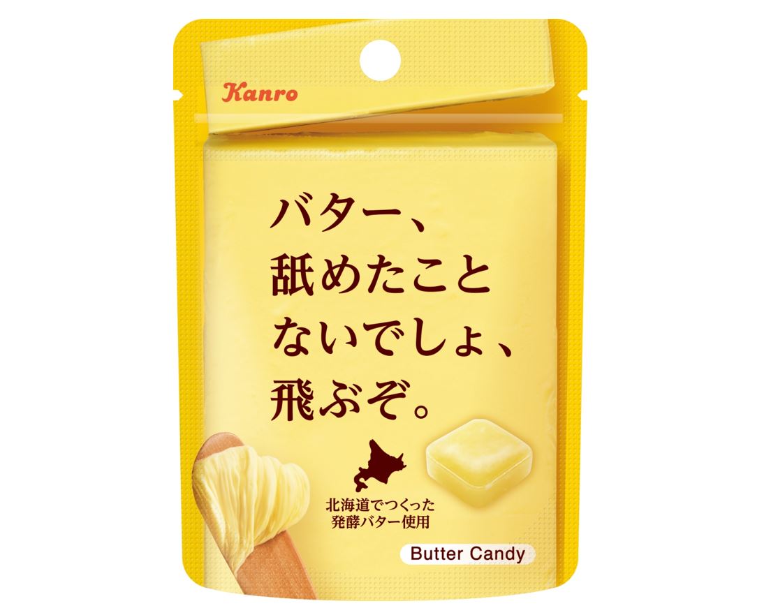 カンロから発売の、バターキャンディ飛ぶぞの写真。黄色い小さな袋の中央には、バター、なめたことないでしょ、飛ぶぞ。というテキストと、バター、キャンディと北海道のイラストがかかれています