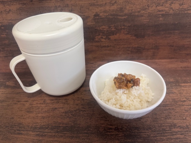 画面ひだりがわにマグ、みぎがわにマグでたいたごはんがしろいおちゃわんにもりつけられた写真。ごはんのうえには青唐辛子いりのお味噌がちょこんとのっています