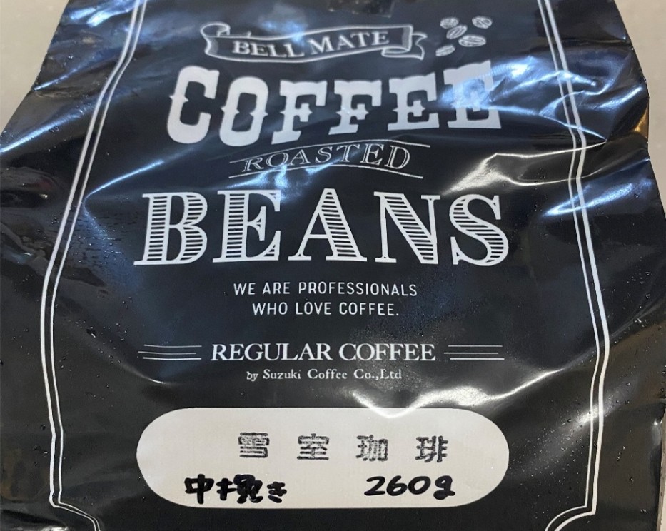 「雪室珈琲」(ゆきむろこーひー)という焙煎したコーヒー豆のパッケージが写っています。パッケージ中央には、白抜き文字で「BELL　MATE」「COFFEE」「ROASTED　BEANS」と大きく記されており、その下に「WE　ARE　PROFESSIONALS　WHO　LOVE　COFFEE」という英文と「REGULAR　COFFEE」「by　Suzuki　Coffee　CO.,Ltd」という記載があります。全体は黒を基調としたシックで落ち着いたデザインの袋で、光沢のある素材が高級感を漂わせています。