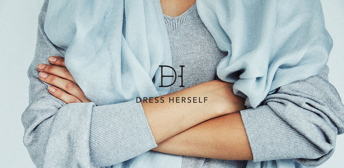 ドレスハーセルフのブランドイメージ写真。腕をくんだ女性の、うで部分がアップになっています。シルク製のニットとストールを巻いています